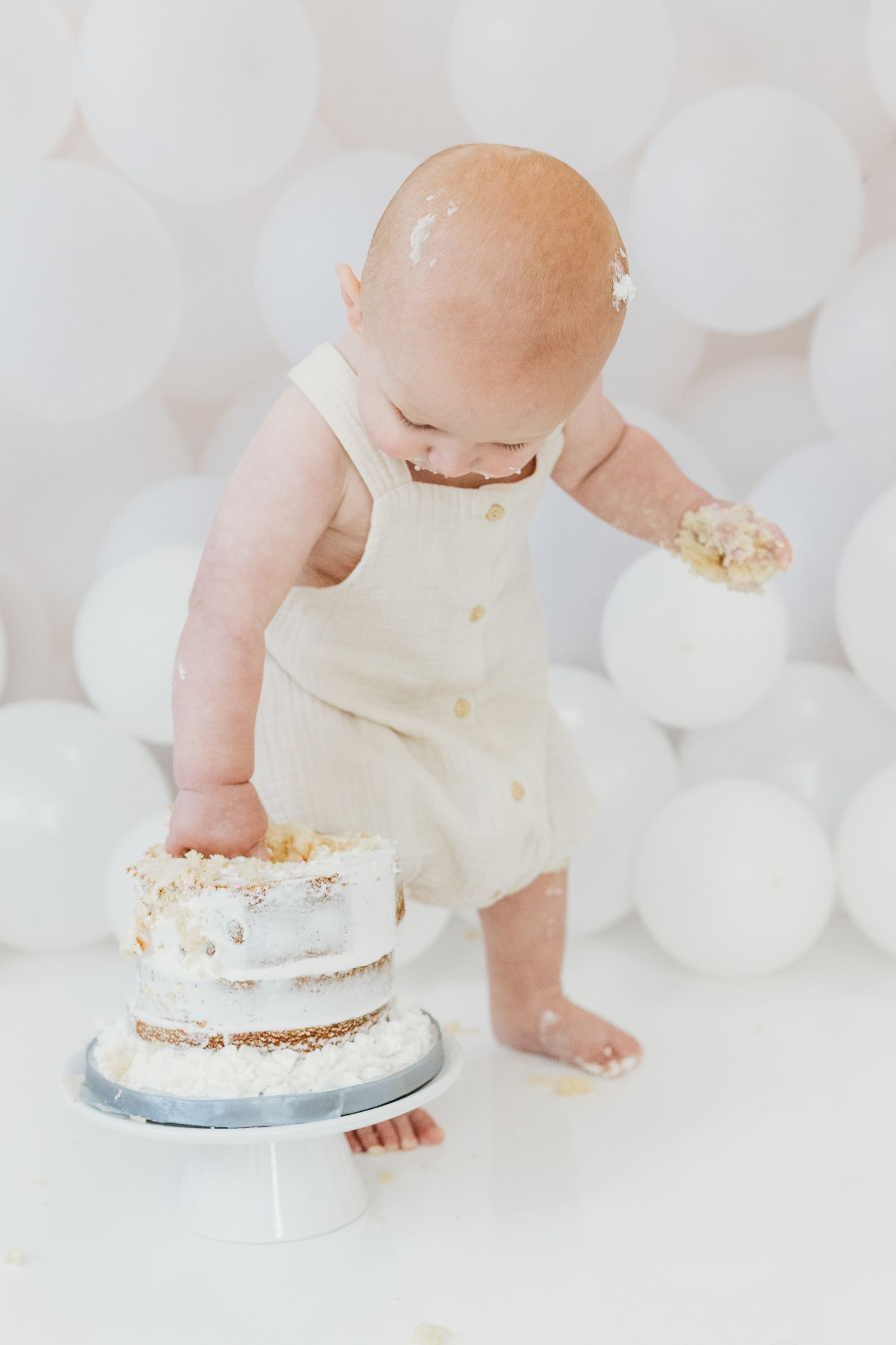 Toddler enjoying first birthday cake smash at Mapperley studio, Nottingham photographer capturing joyful milestone portraits.