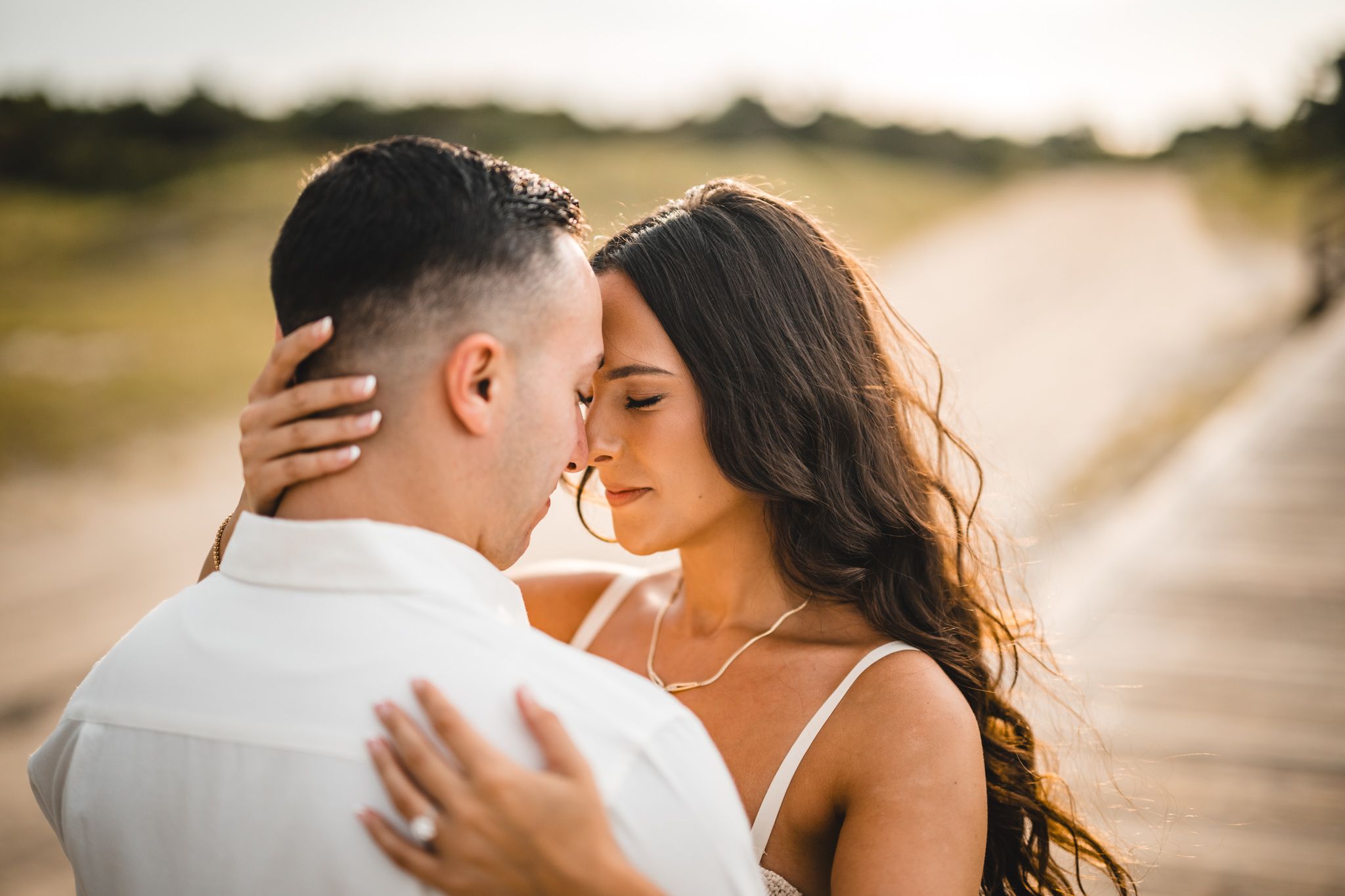 Intimate moments captured between a couple during a sunset beach photoshoot.