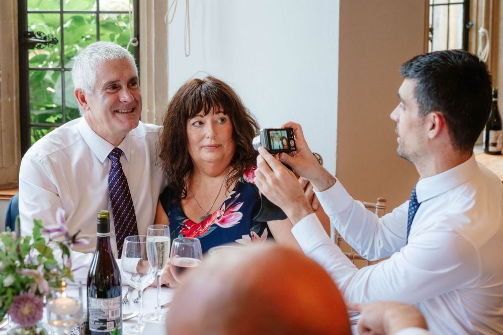 Coombe Lodge Somerset Wedding Photographer Zara Davis Photography guests taking photos of each other during wedding breakfast