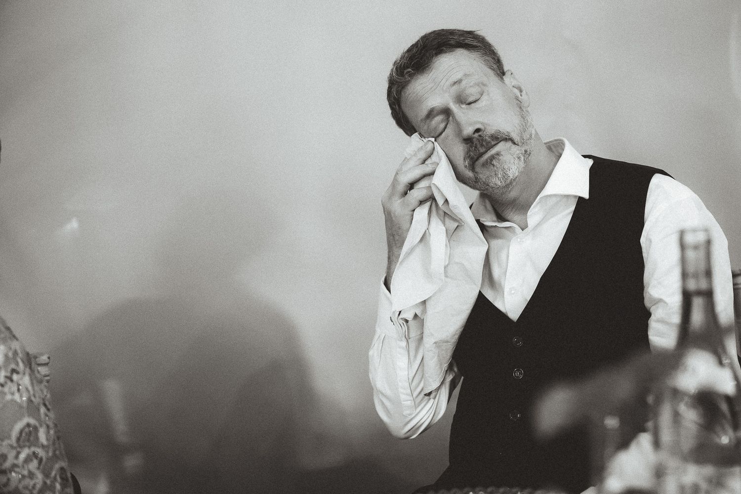 A black and white collage showing someone in formal attire appearing increasingly intoxicated across multiple frames.