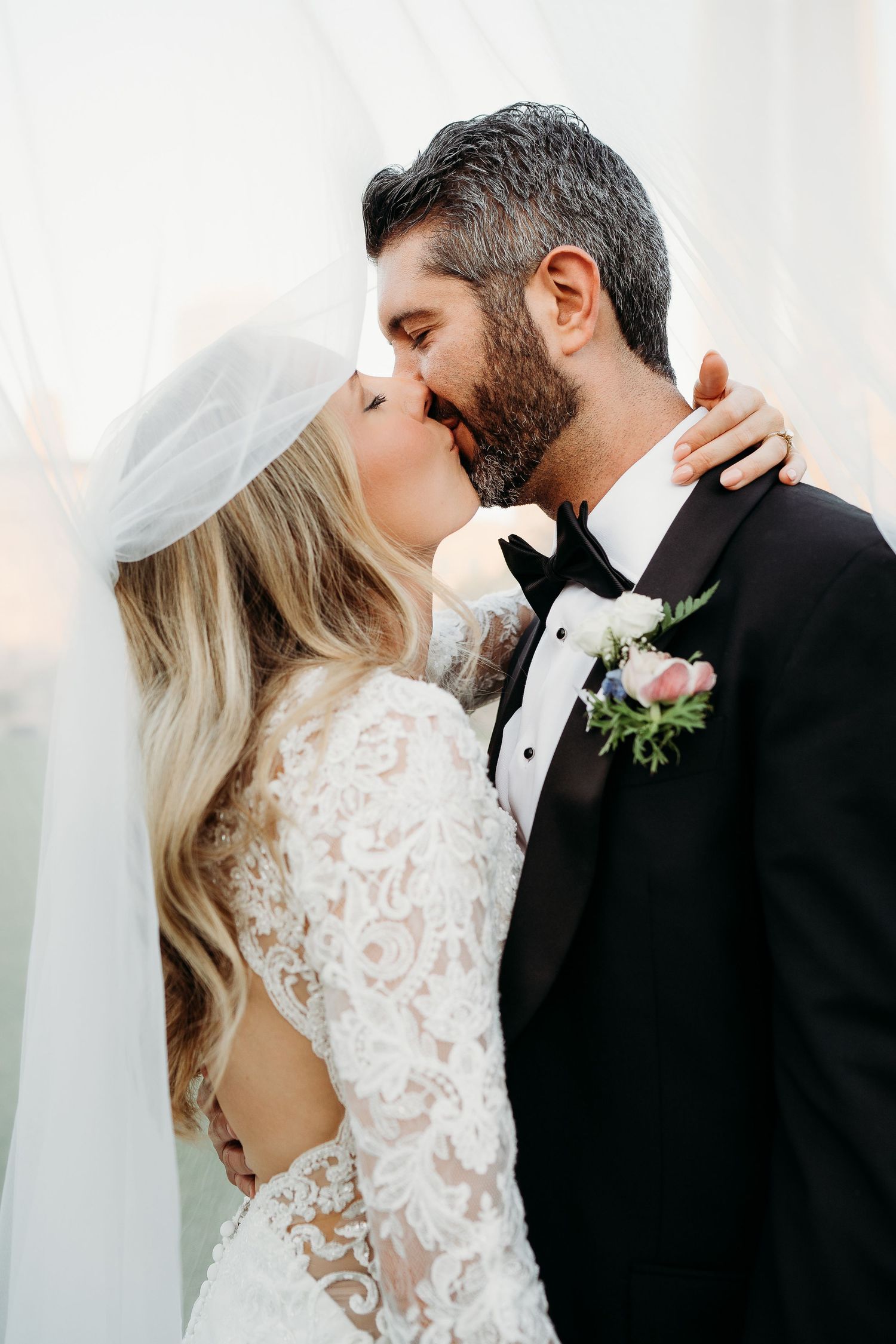 Close-up romantic wedding portraits of newlyweds sharing intimate kisses in elegant formal attire.