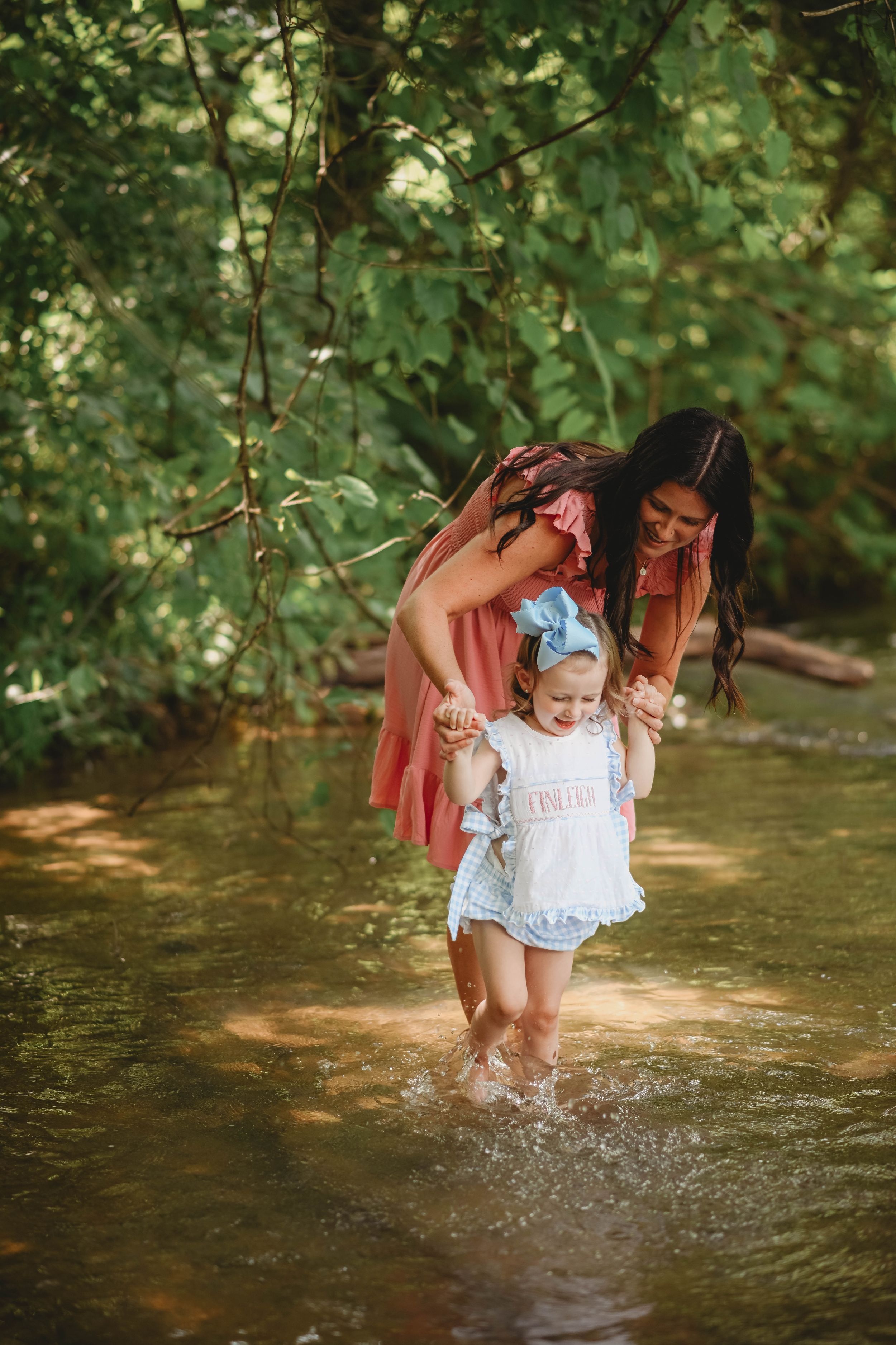 Playful splashing and laughter in a creek during a summer photo session.