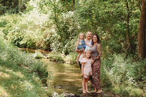 Natural outdoor family photos taken by a scenic forest stream.