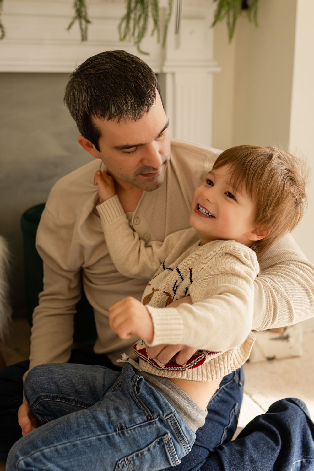 A sweet candid sequence of playful moments between parent and child captured on a couch in natural light.