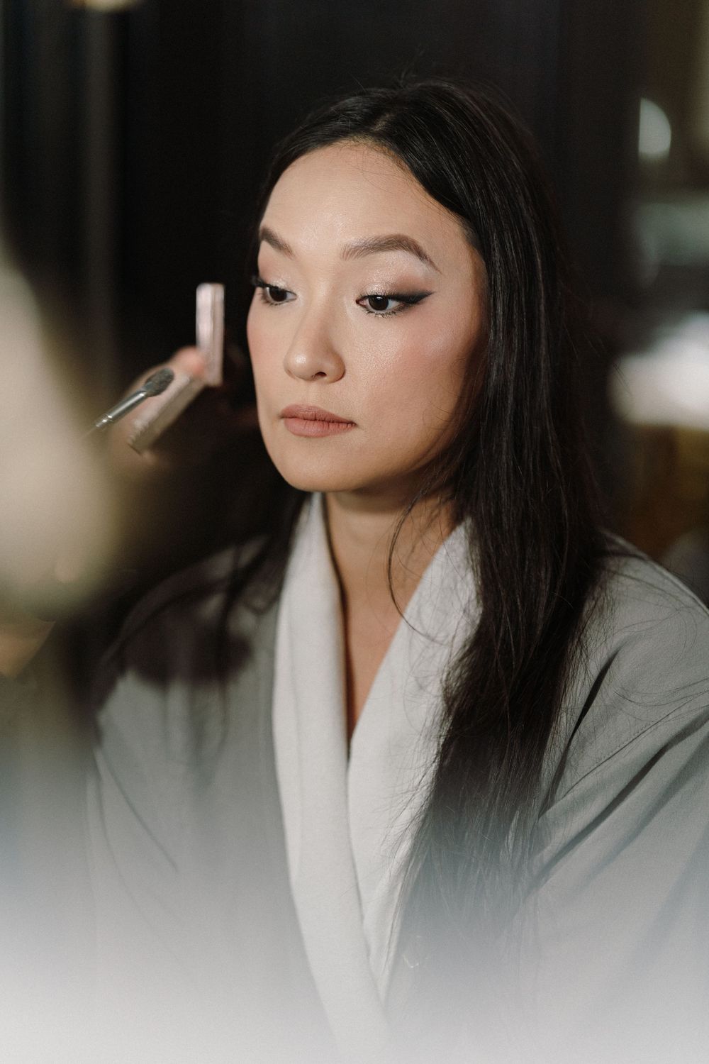 Artistic series of close-up beauty shots featuring winged eyeliner and glossy lips in moody lighting.