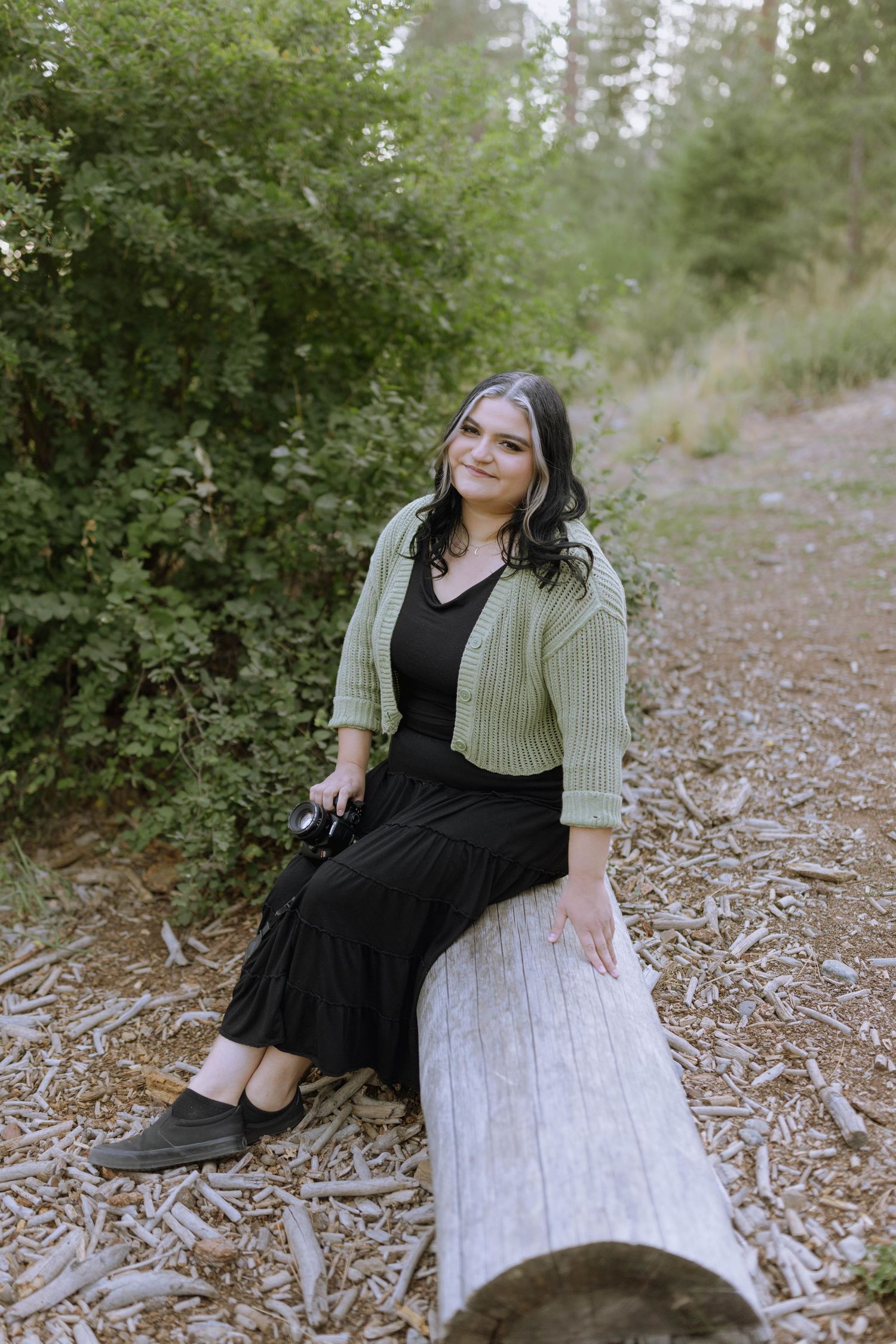 Portrait of local photographer Gabbie Rose Photo wearing a black outfit and green cardigan at Corbin Park in Spokane, WA.