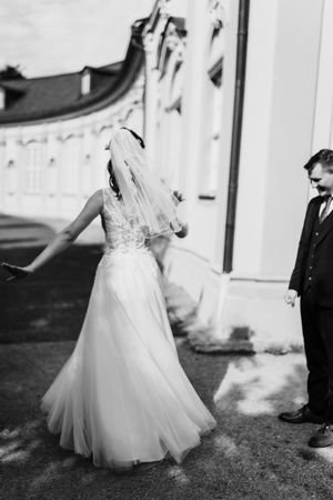 A couple dances together outdoors in wedding attire with the bride's white dress flowing in movement across four photos.