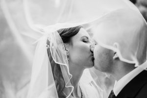 Black and white close-up shots of tender wedding moments under flowing veils.