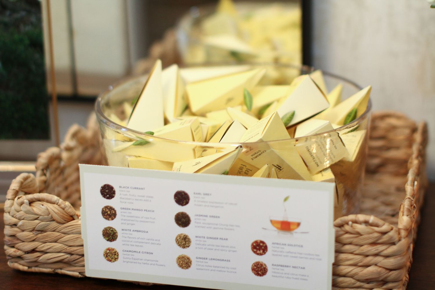 White paper menu cards displayed in woven baskets alongside table settings at a restaurant.