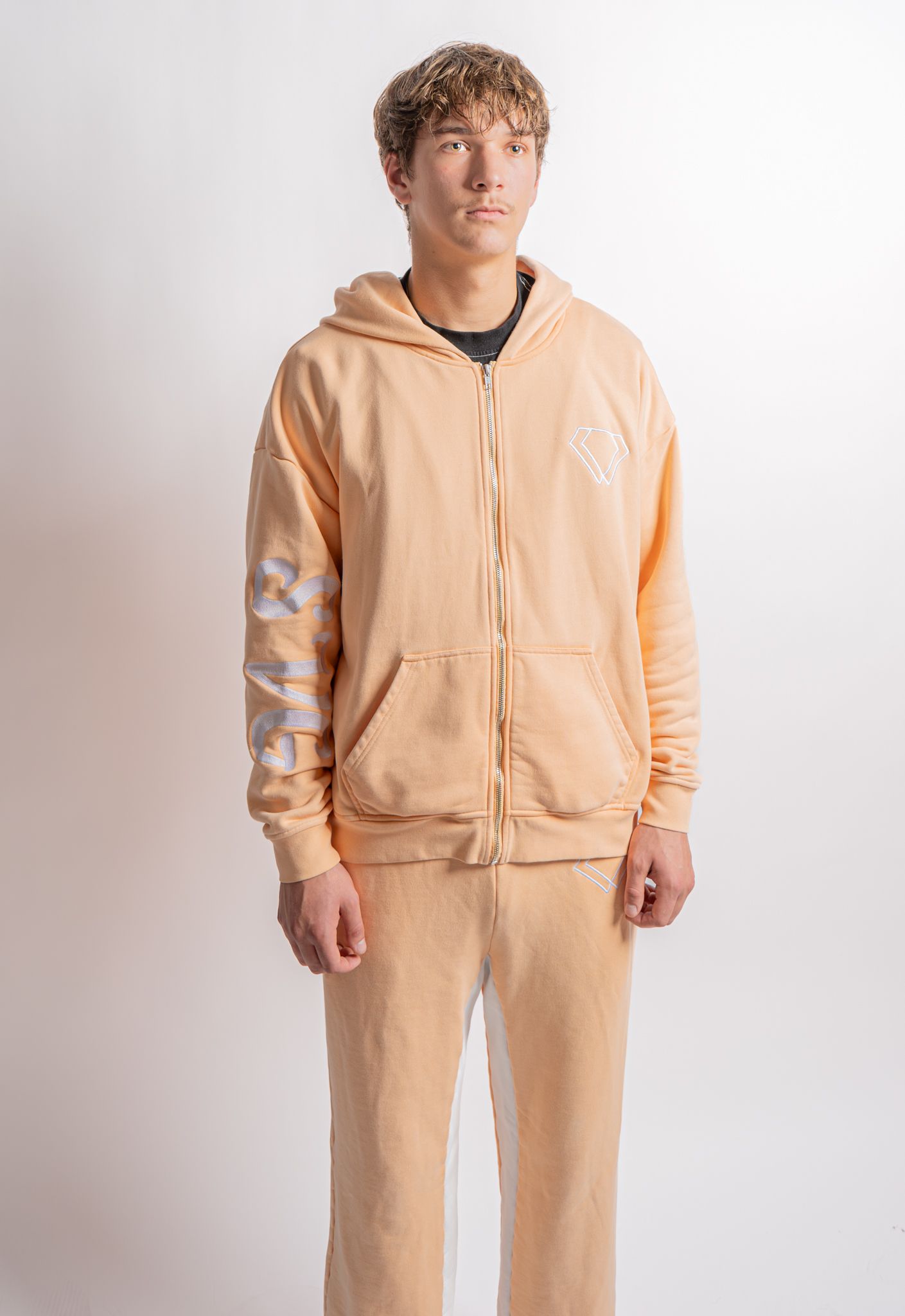 A peach-colored zip-up hoodie and matching sweatpants set shown from multiple angles on a light background.