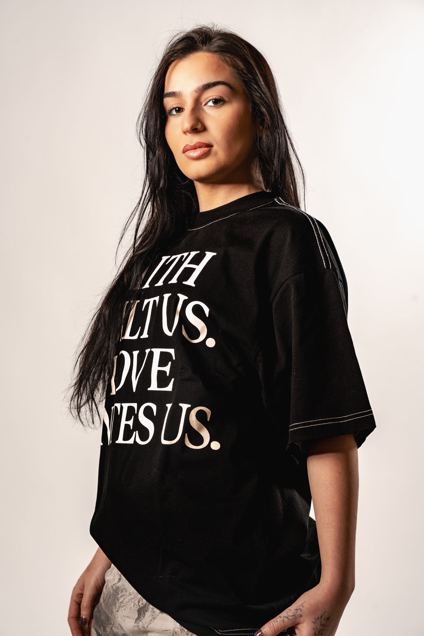 A person wearing a black t-shirt with 'JESUS' text shown from multiple angles against a white background.