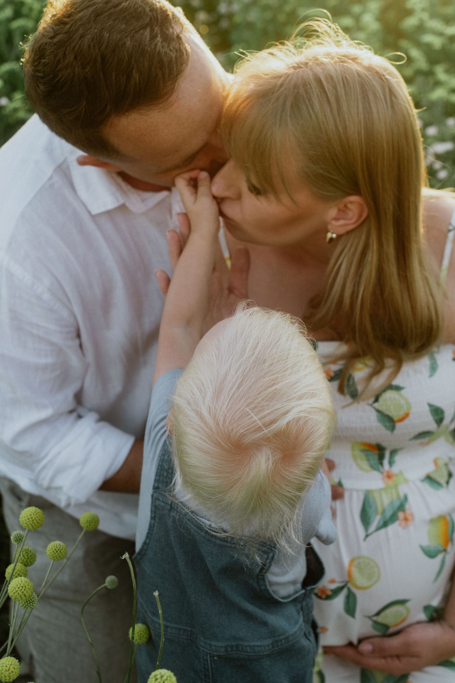 Bliski, intymny portret rodzinny, objęci kobieta i mężczyzna wraz z dzieckiem.