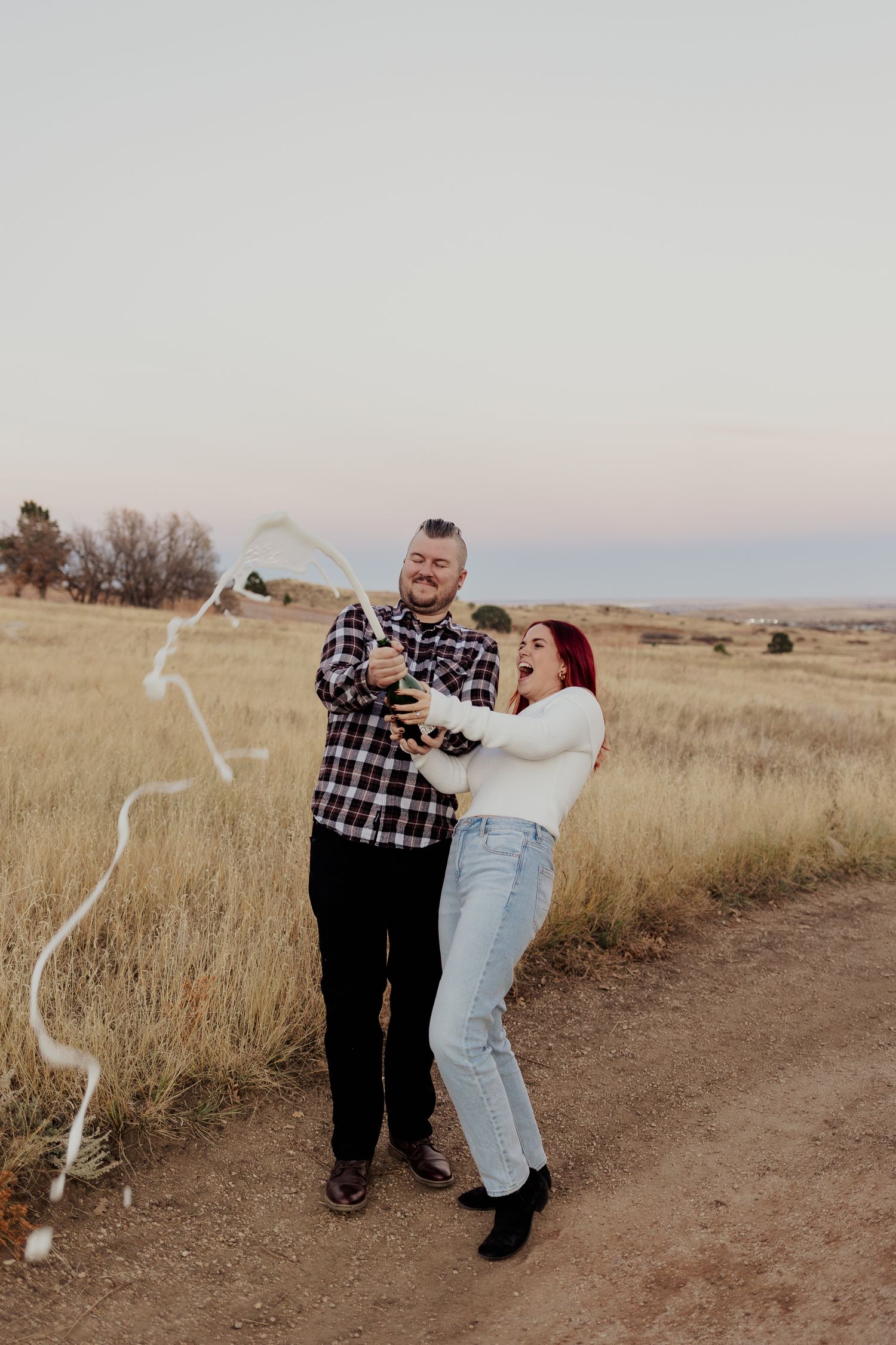 A couple embraces and celebrates in a romantic photoshoot across a series of four images in golden fields at sunset.