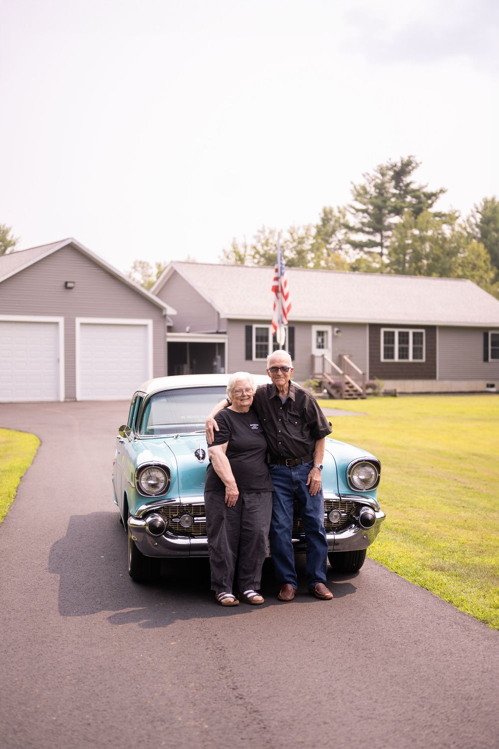 Classic turquoise car photoshoot with people posing by vintage Chevrolet.