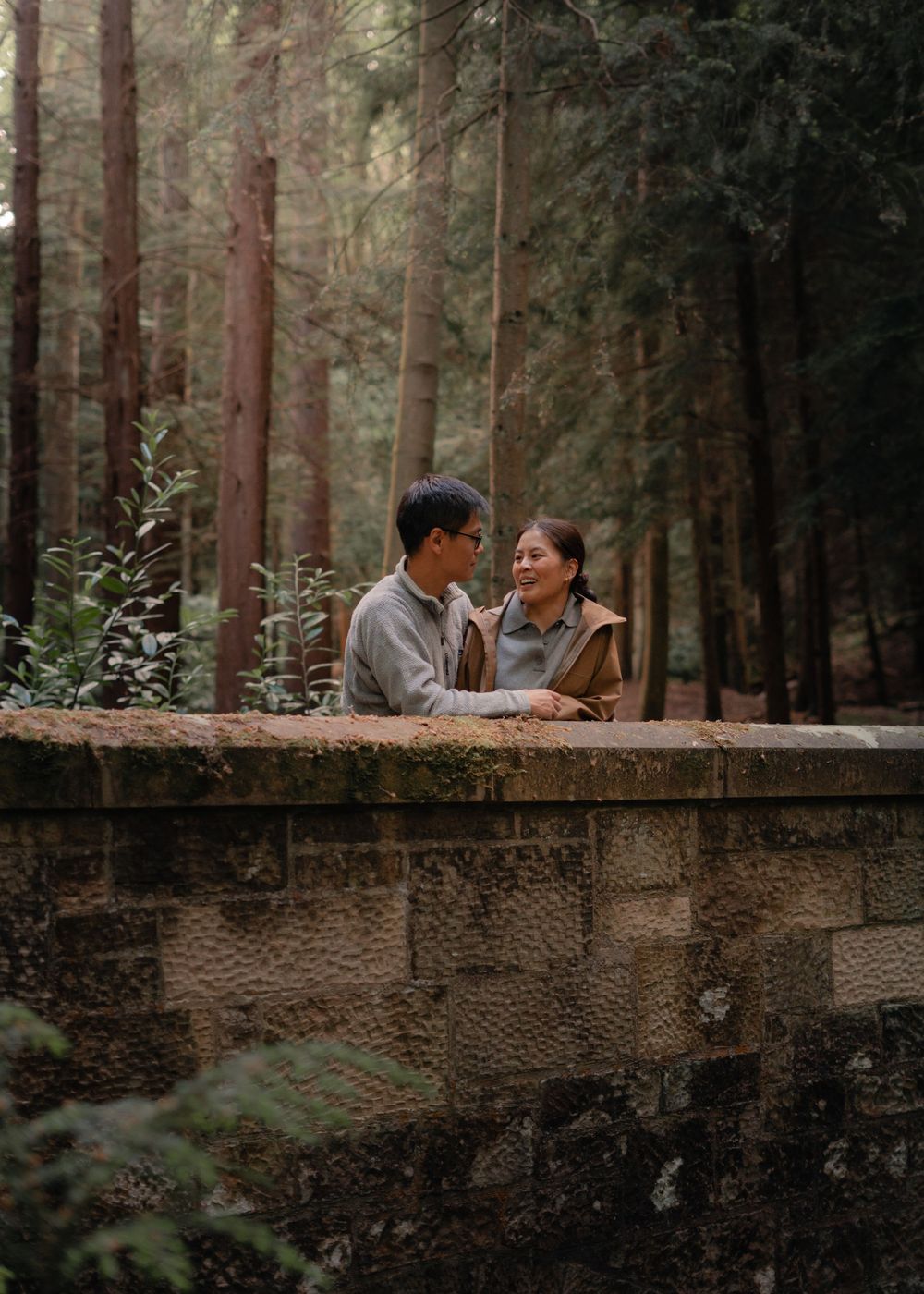 couple share romantic moment on an old stone bridge in Falkland, captured by Scottish love story and couples photographer