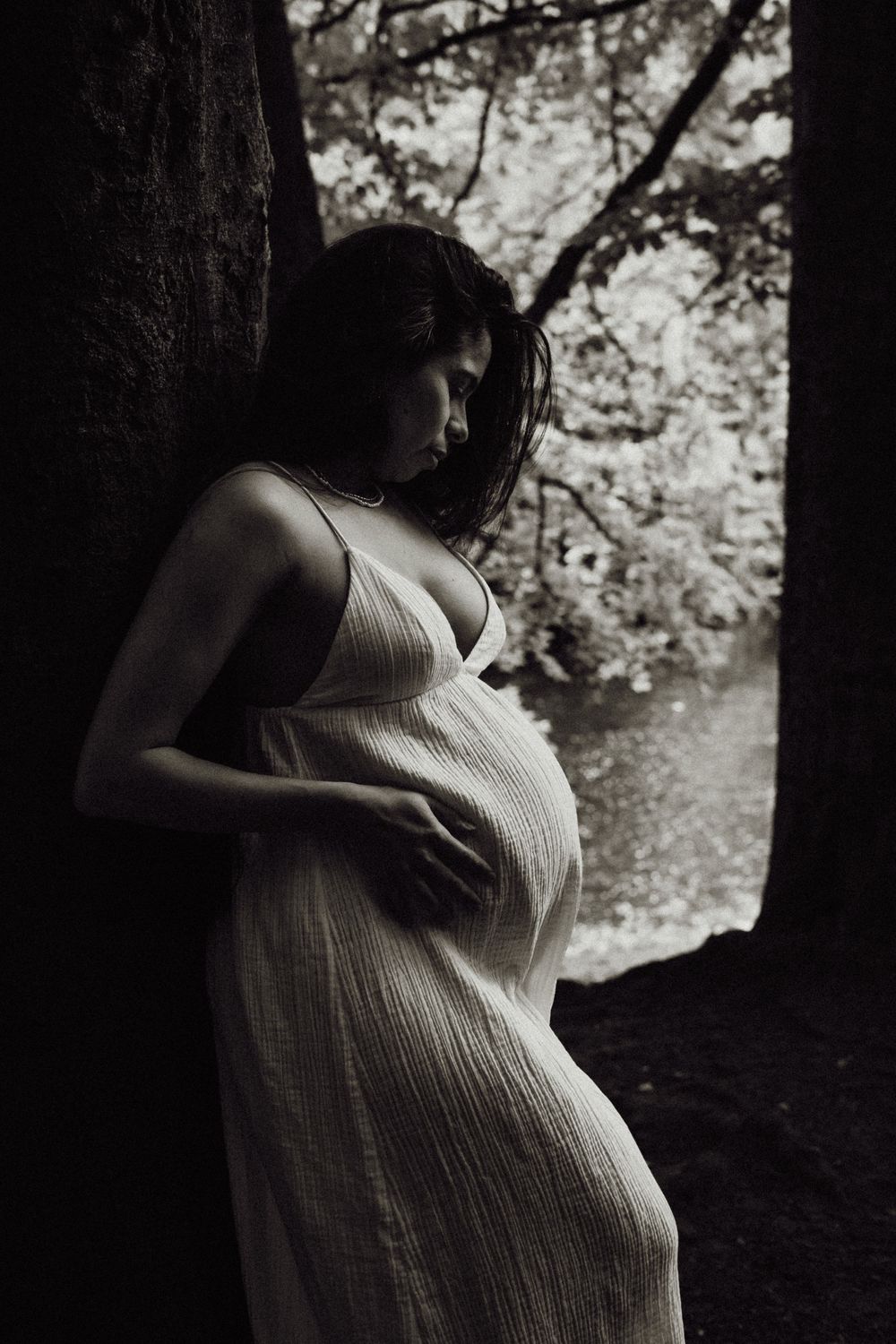Tender maternity photo of expectant mother holding her belly in Scottish woodland  taken by Perthshire Photographer
