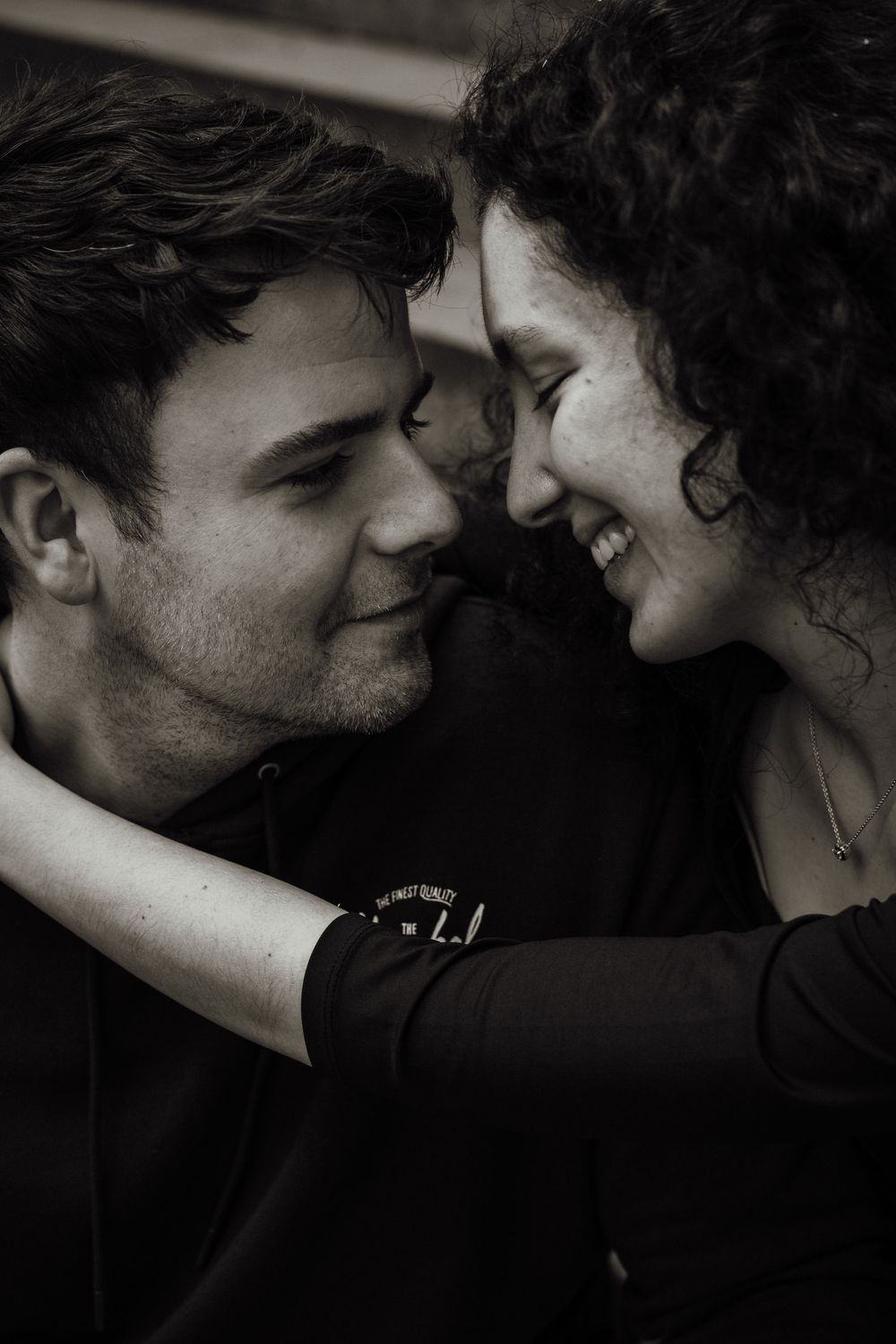 Tender engagement photo of couple sitting together in Edinburgh taken by Scottish Photographer