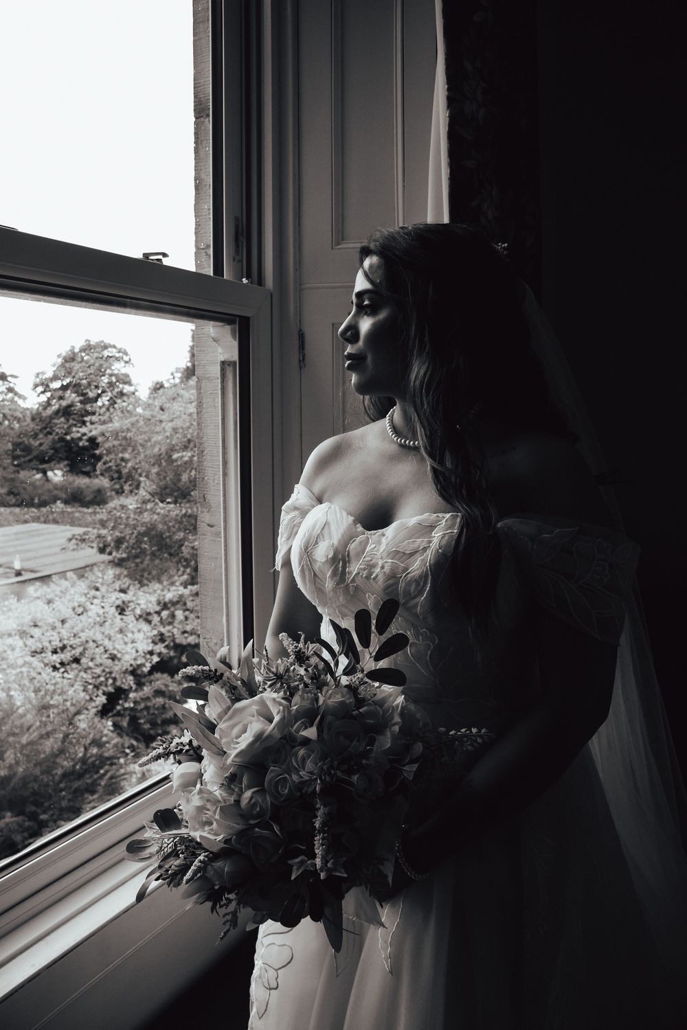 Natural wedding photo of bride looking out of a window in Dundee, Scotland by Scottish wedding photographer
