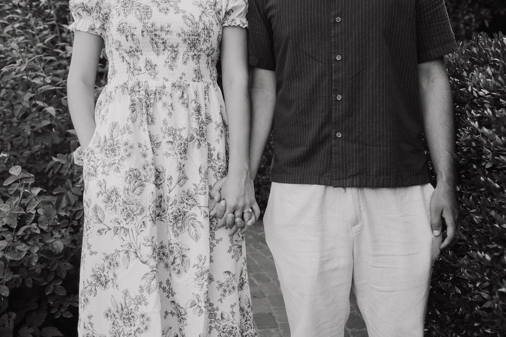 A close-up side view of a couple in casual attire standing together.