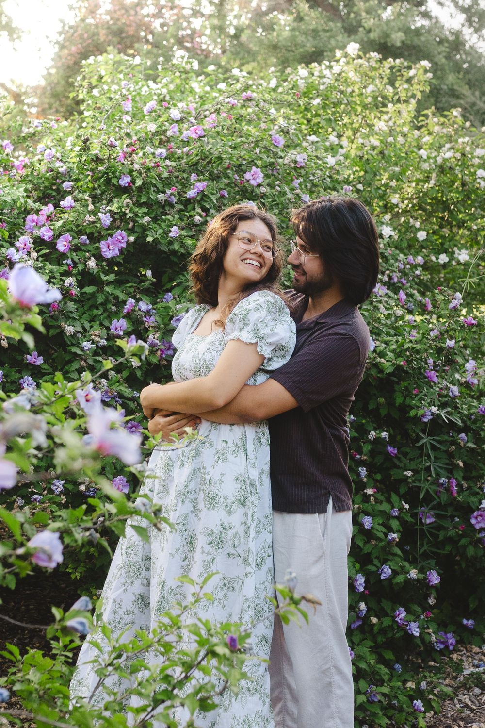 A joyful embrace among blooming purple flowers in a garden setting.