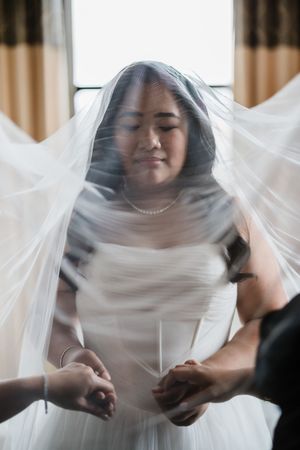Sequence showing the delicate placement of a sheer white bridal veil.