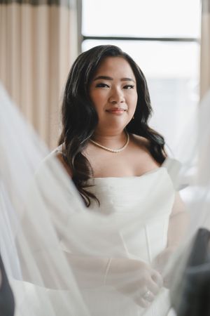 Artistic bridal portrait series featuring a classic white wedding dress and pearl necklace.