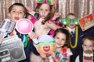 Group of children enjoying Flawless Photos Photo Booth with fun props at a wedding.