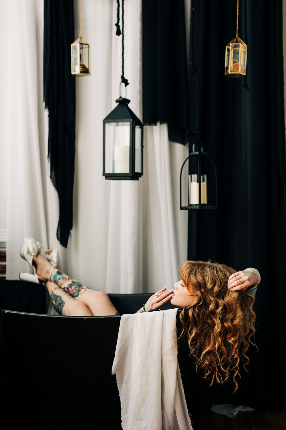 Fashion portraits show a person in a white fabric drape against a dark background with hanging lanterns boudoir photography Loganville