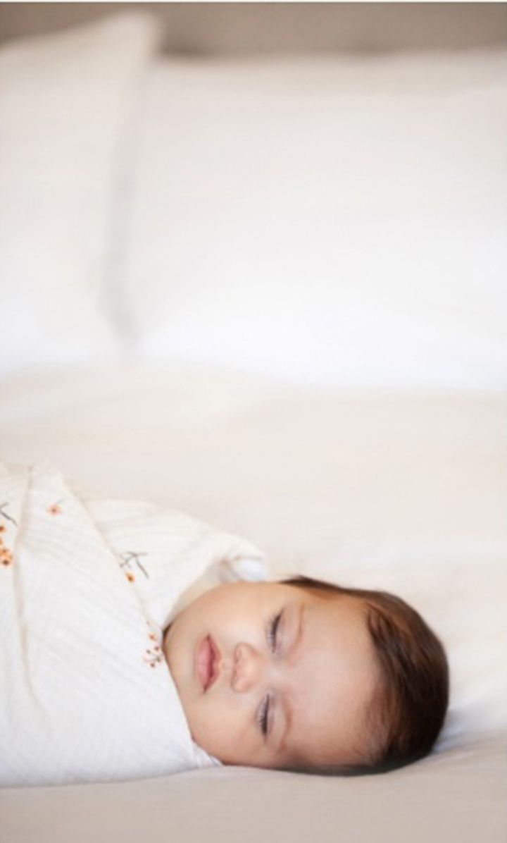 A sleeping baby rests peacefully on white bedding in a series of serene photographs.
