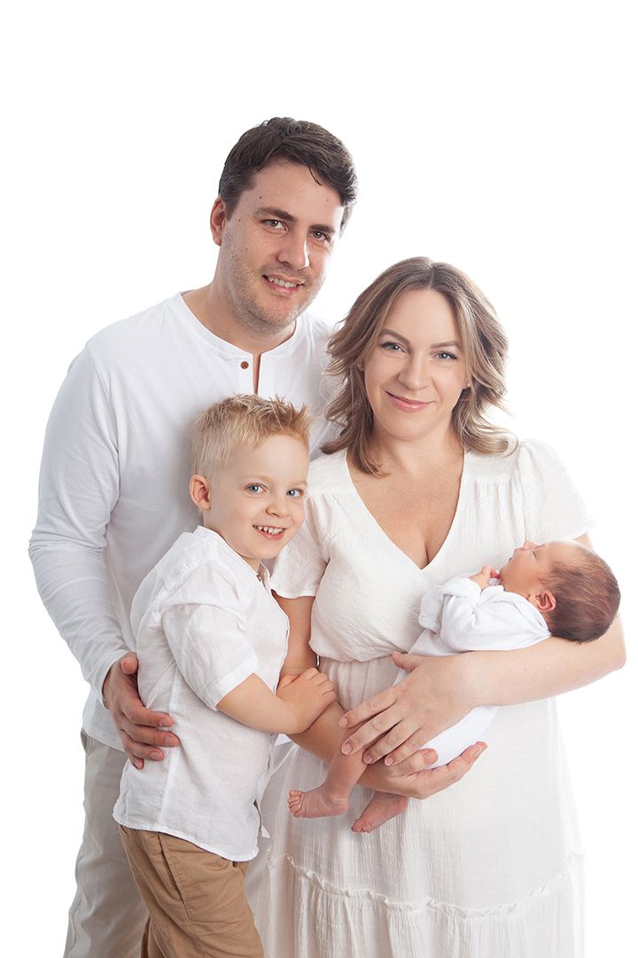 A family in white clothing poses together against a white background in a sequence of connected images.