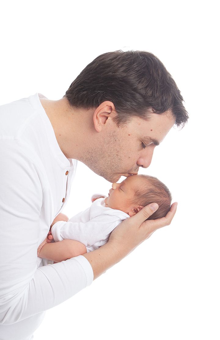 Three sequential photos show a person in white bending forward and lifting an infant in a tender gesture.