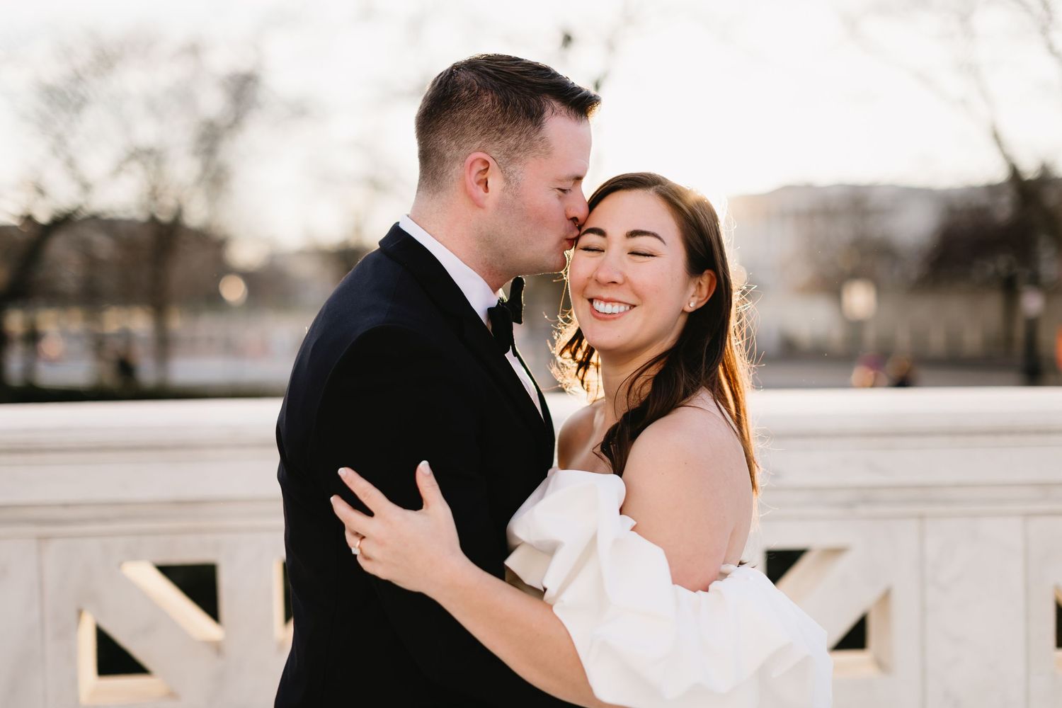 Candid wedding photo of a couple embracing and laughing outdoors. Twin Cities wedding photography.