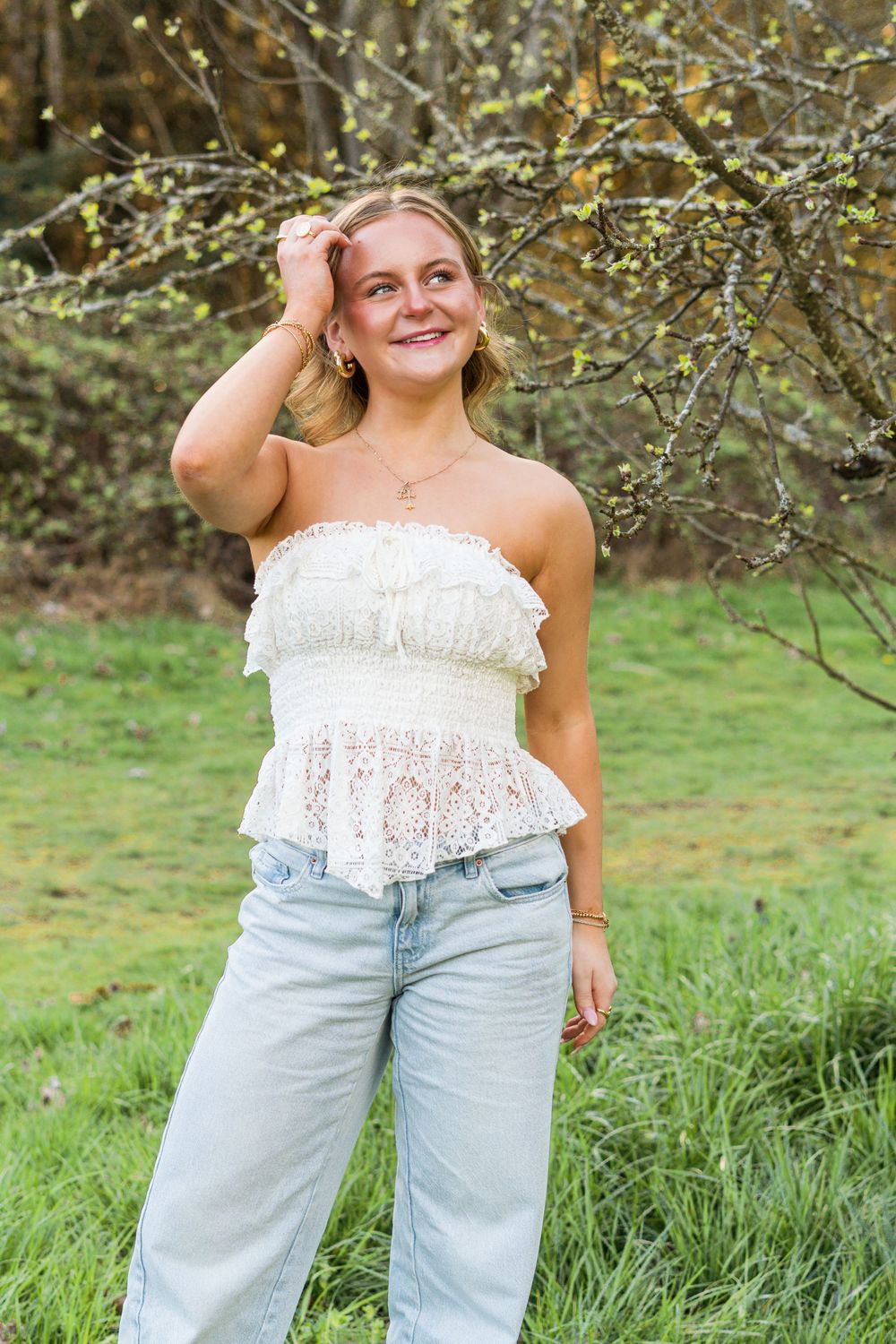 A series of outdoor photos showing someone wearing a white lace top and light wash jeans in a garden setting.