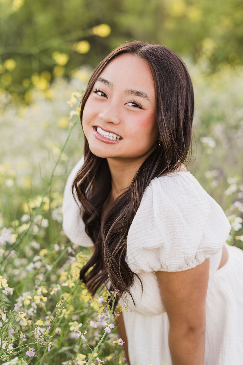 Portrait in a spring meadow with white flowers and soft natural lighting.