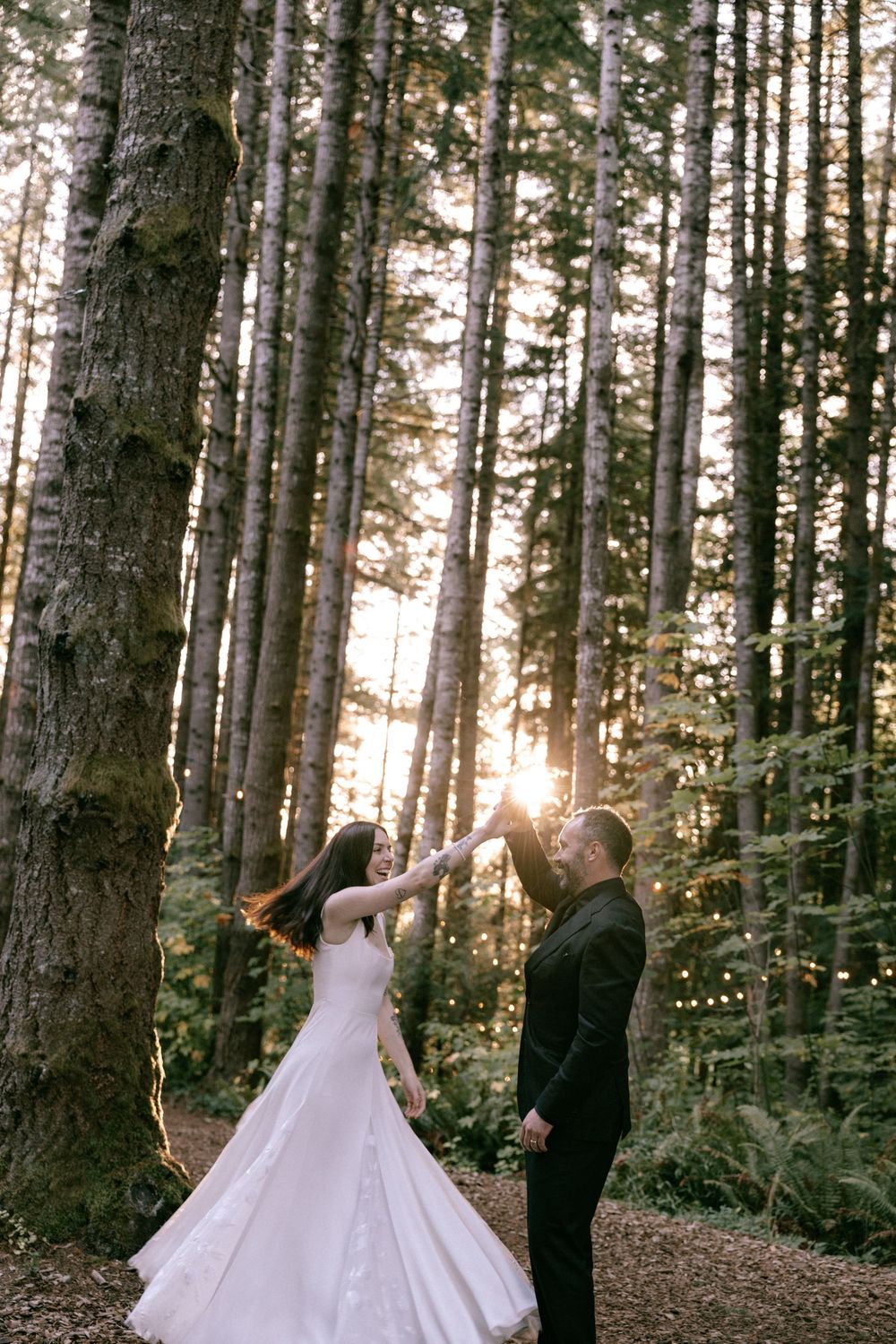 A romantic wedding photo series in a serene forest setting with sunlight filtering through tall evergreen trees.