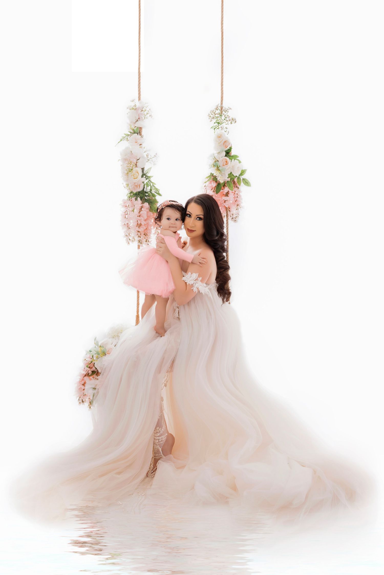 Ethereal studio portrait with suspended floral arrangements and flowing white gown.