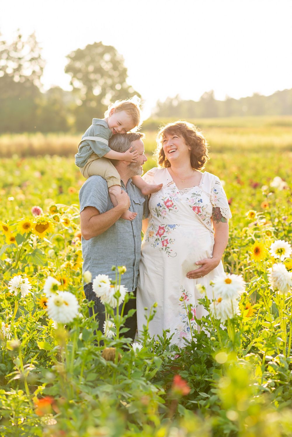 Family enjoys a tender moment in a sunflower field at sunset at The Flower Lady and Gent.
