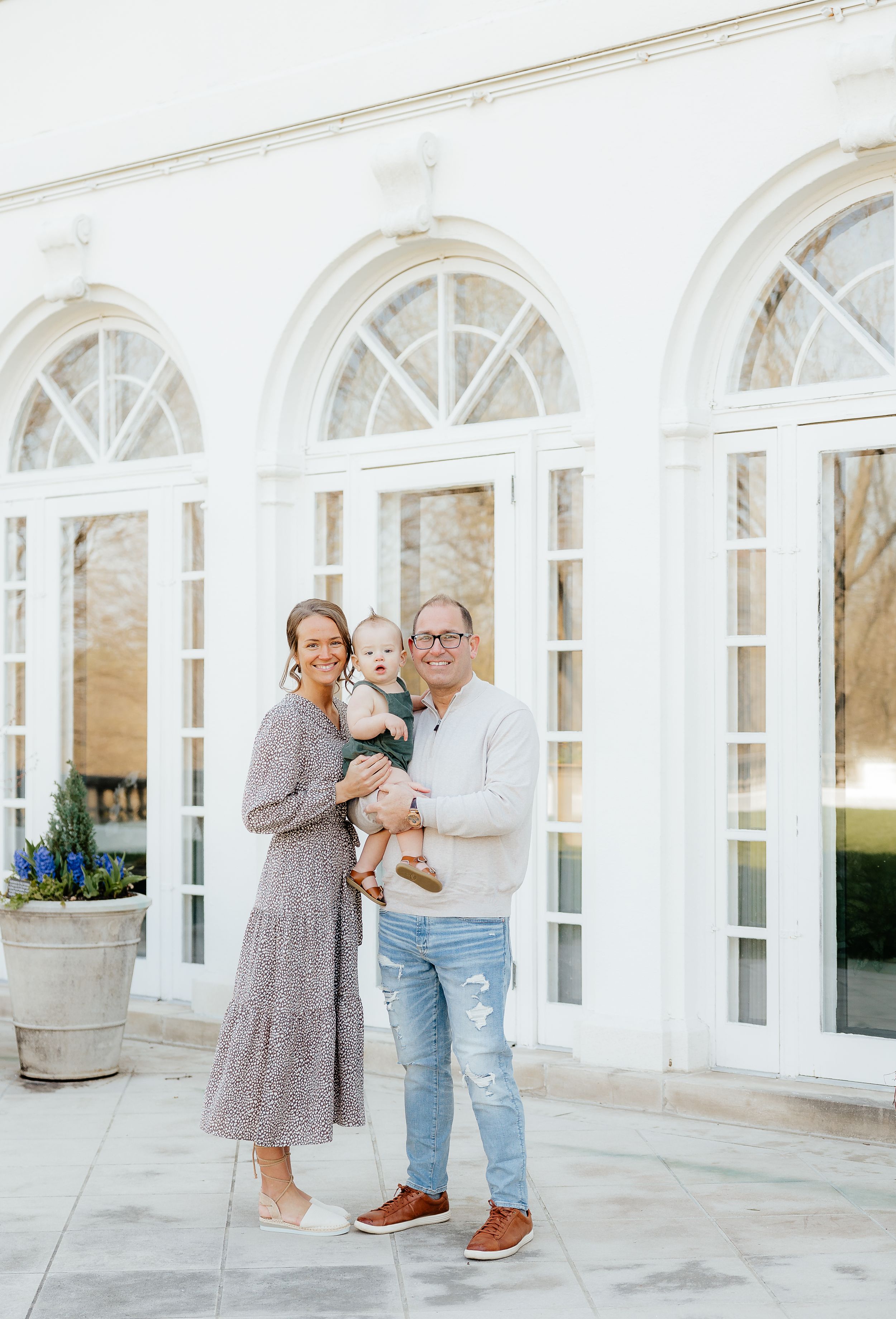 Sweet interaction between two people near elegant white columned building exterior.