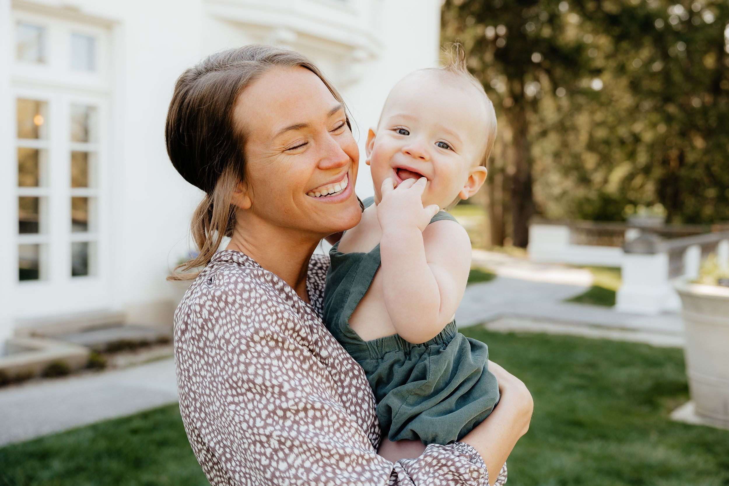 Joyful outdoor portrait showing tender moment between parent and baby.