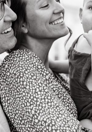 Close-up black and white portrait of a couple sharing an intimate moment and laughing together.