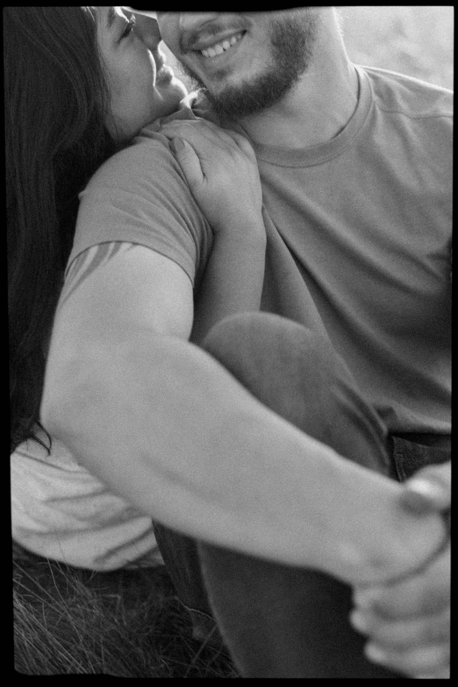 Black and white close-up of couple sharing tender moment outdoors.