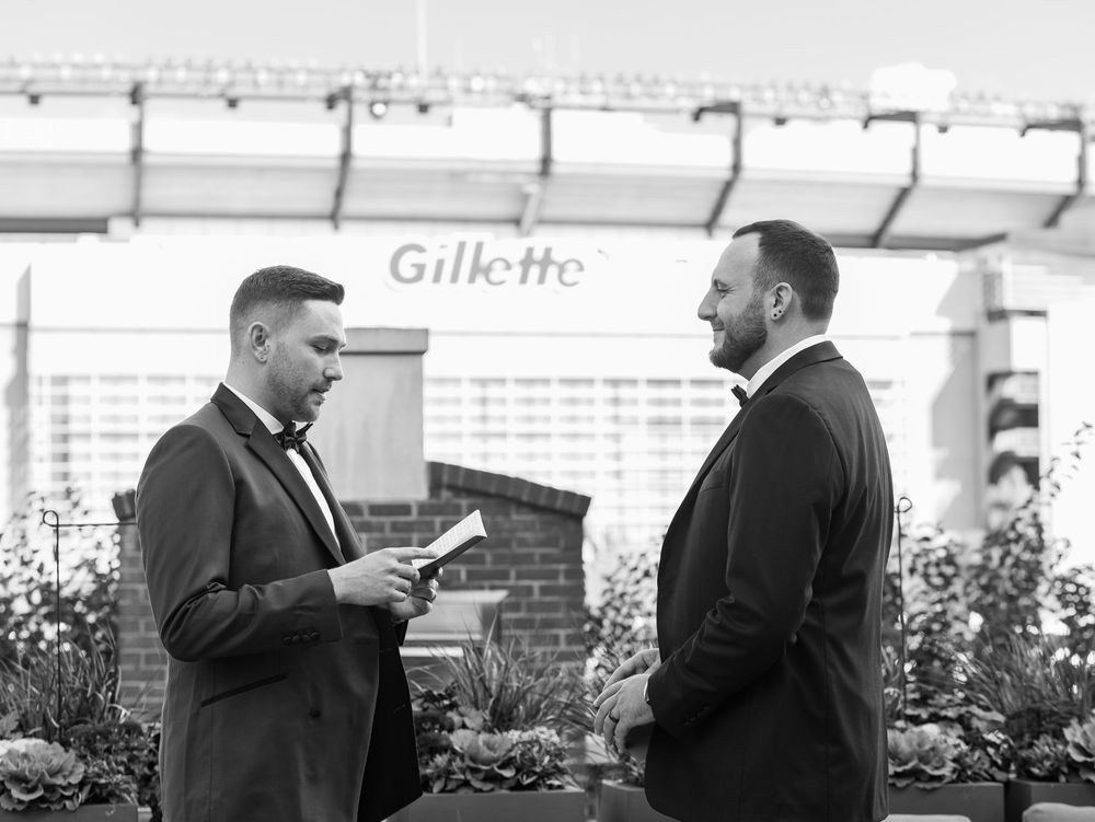 A gay couple shares their private vows during their first look at their wedding at Gillette Stadium in Massachusetts.