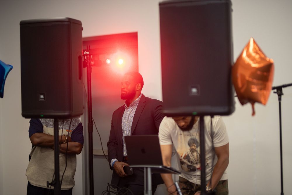 A performance setup with speakers and red stage lighting in a dimly lit room.