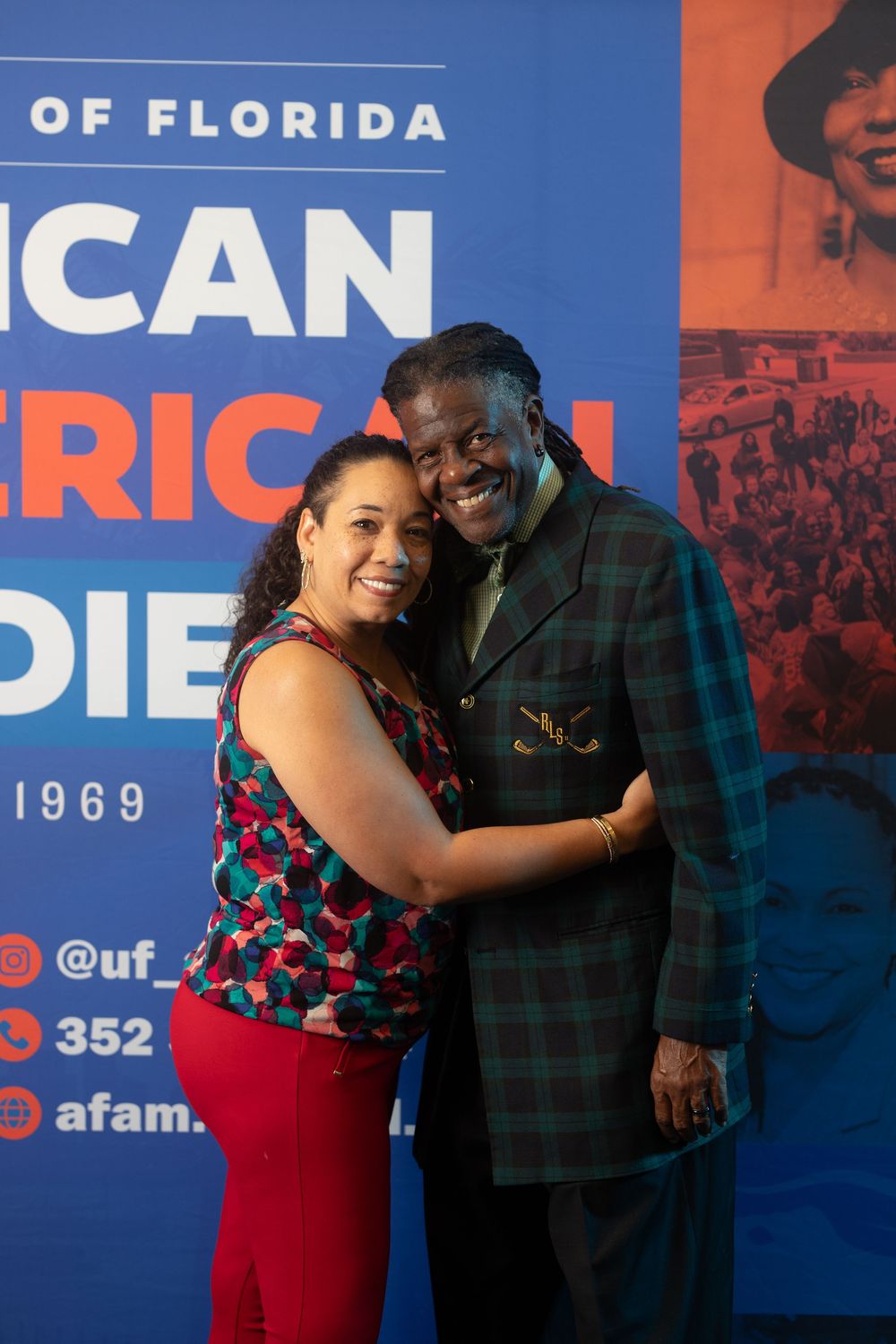 Couple poses together in front of University of Florida African American Studies backdrop.