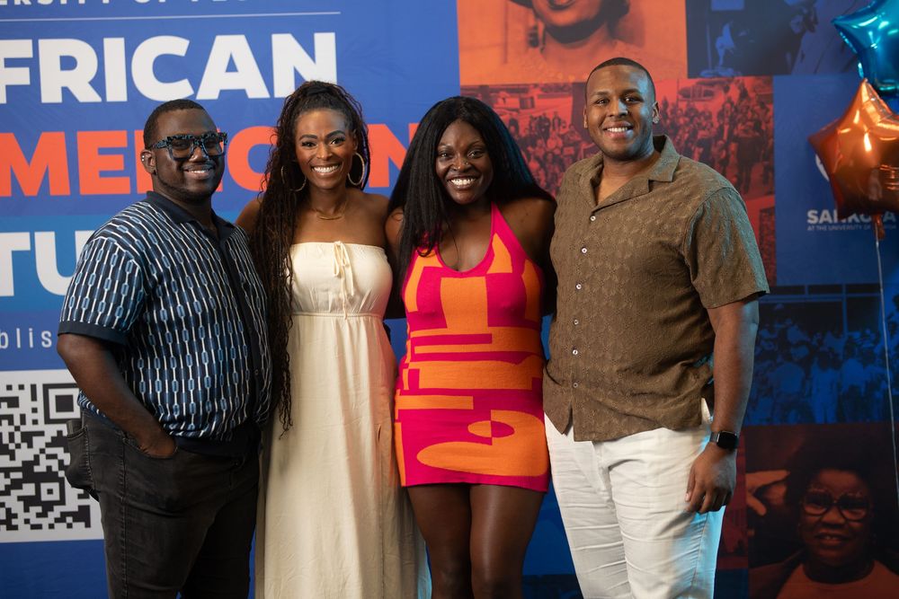 Four people pose together at University of Florida event wearing stylish evening attire.