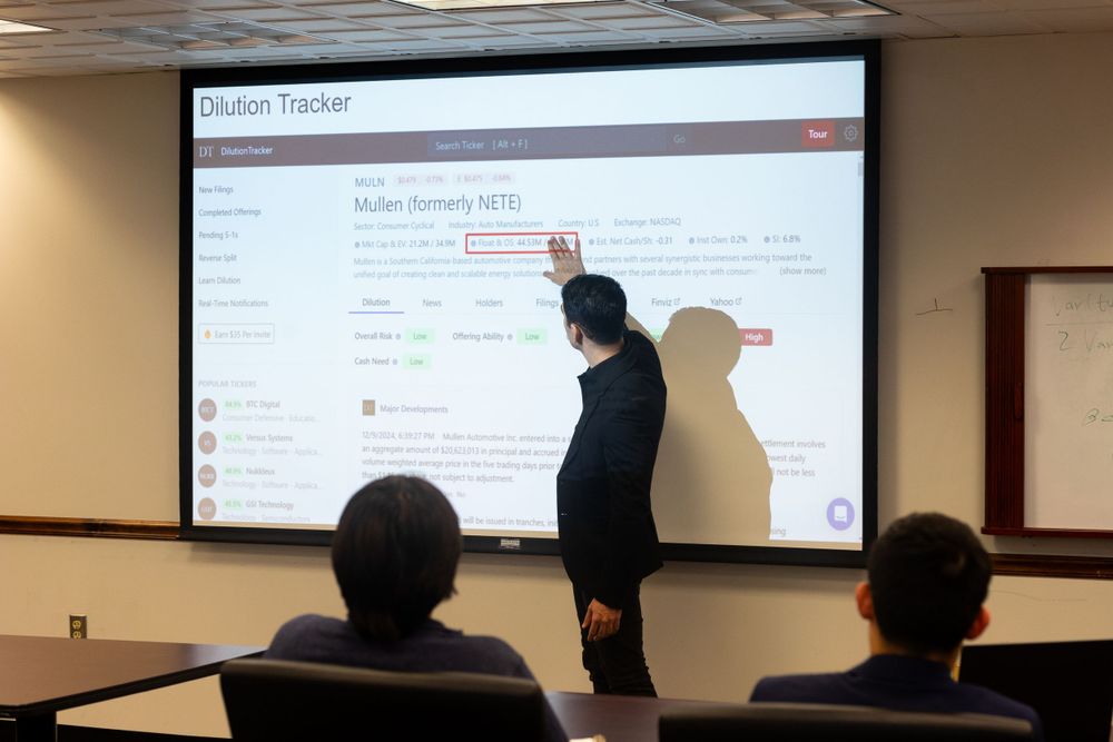 Presenter points to projected screen during business meeting or training session.