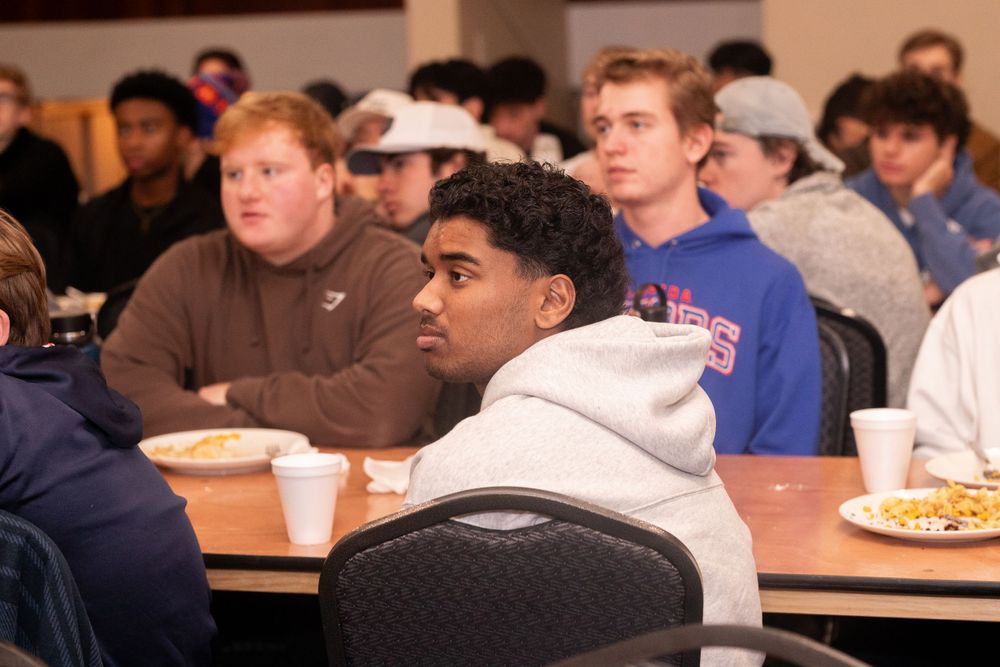 Students attend a lecture while enjoying refreshments in a classroom setting.