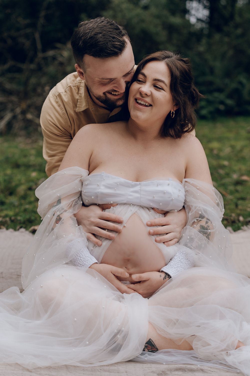 Intimate maternity photo of couple embracing outdoors.