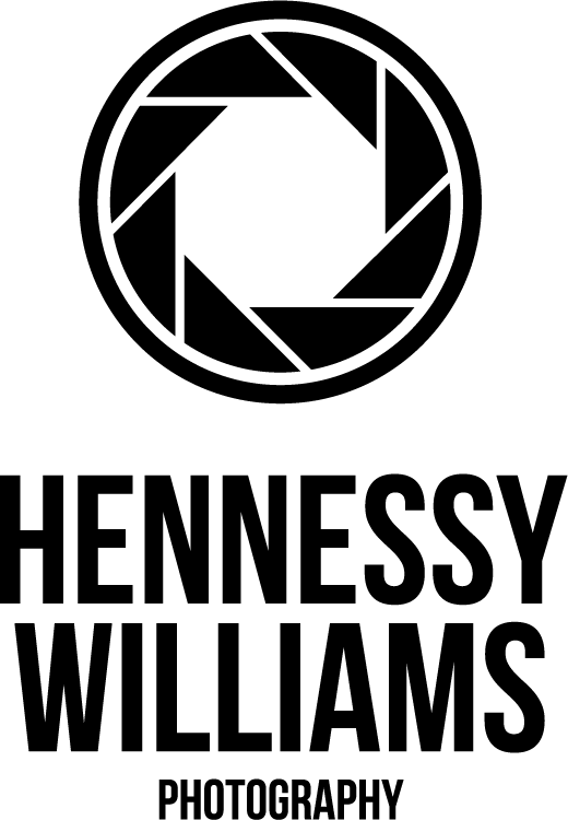 Silhouetted figure stands against dark background holding up a mobile phone in dramatic lighting.