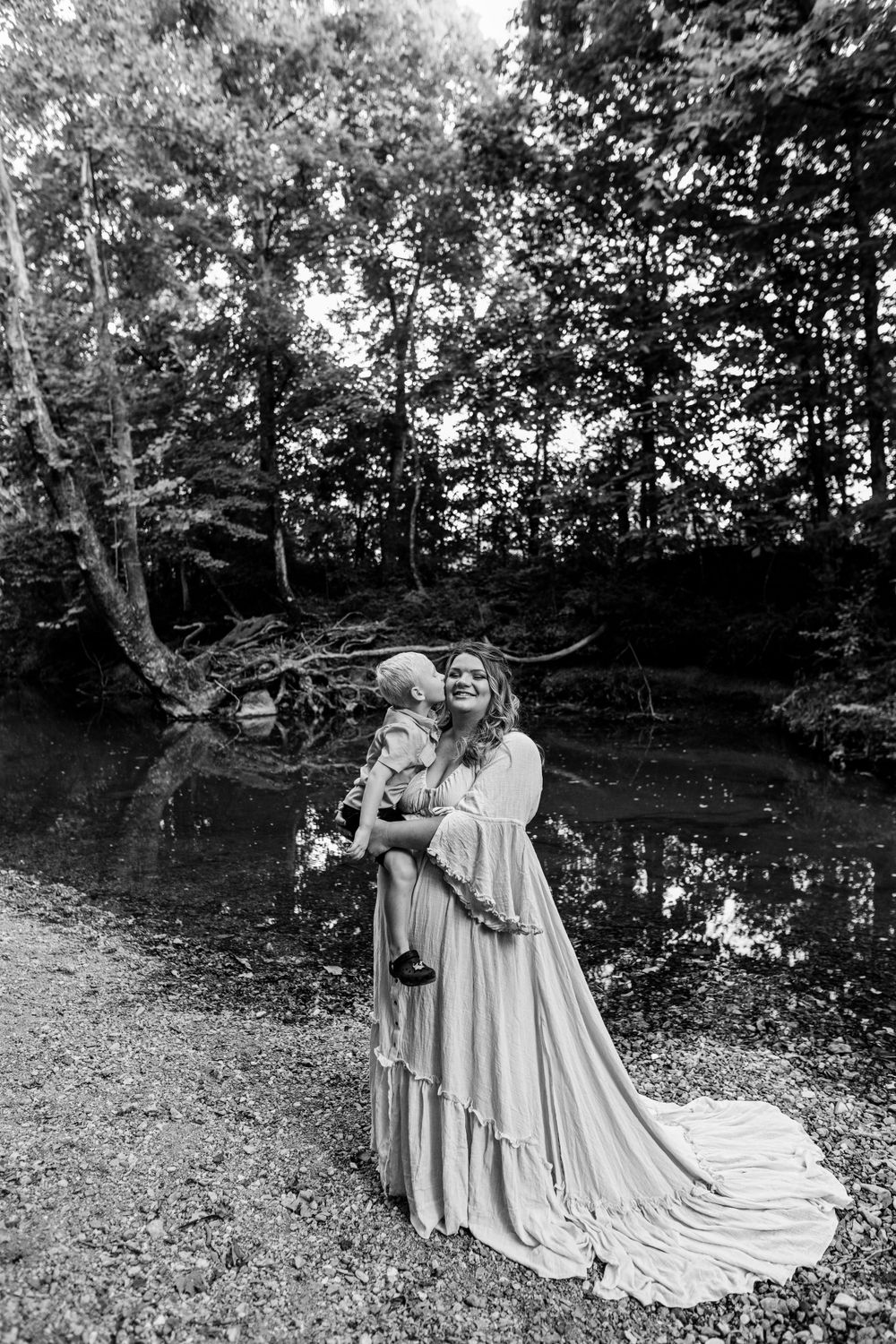 A romantic black and white photograph showing flowing dresses in a wooded setting.